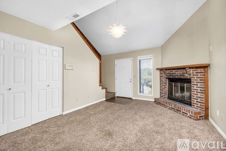 A living room with a fireplace and a carpeted floor.