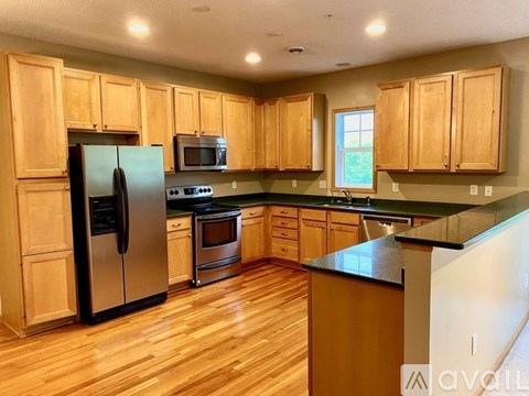 A kitchen with wooden cabinets and a black countertop.