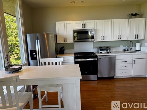 A kitchen with white cabinets and a wooden table.