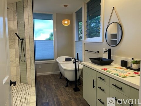 A bathroom with a tub, sink, and mirror.