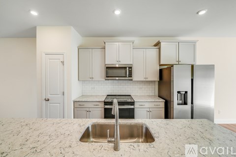 A kitchen with a sink and a refrigerator.