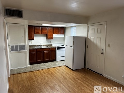 A kitchen with wooden cabinets and a white refrigerator.
