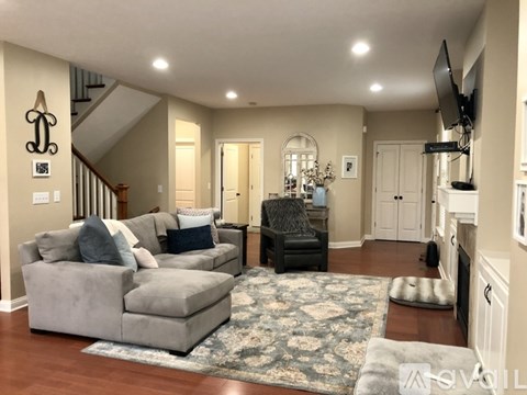 A living room with a grey couch and a black chair.