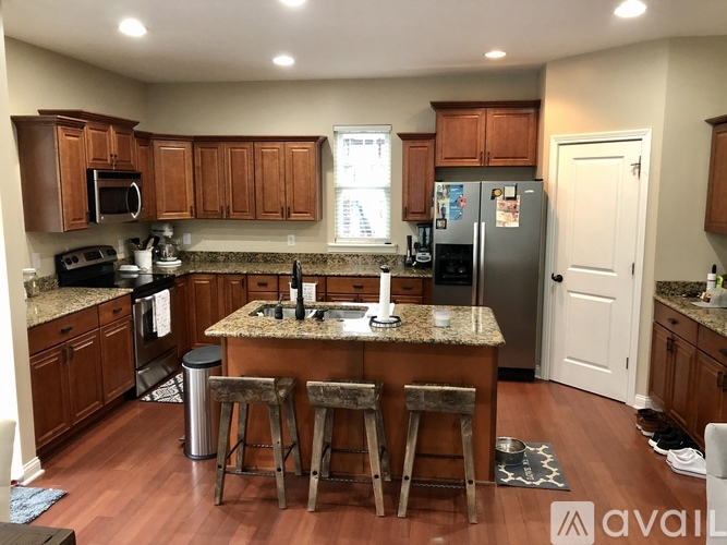A kitchen with brown cabinets and granite countertops.