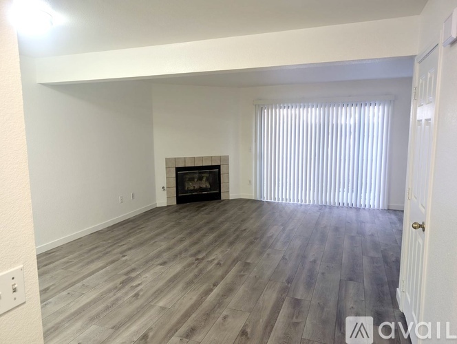 A spacious living room with a fireplace and wooden flooring.