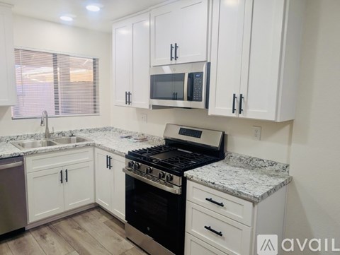 A kitchen with white cabinets and a granite countertop.