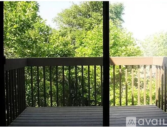 A balcony with a railing and a view of trees.
