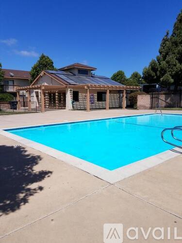A pool with a house in the background.