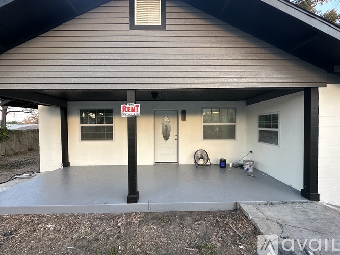 A house with a "Rent" sign in front of it.