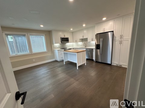 A kitchen with white cabinets and a wooden island.