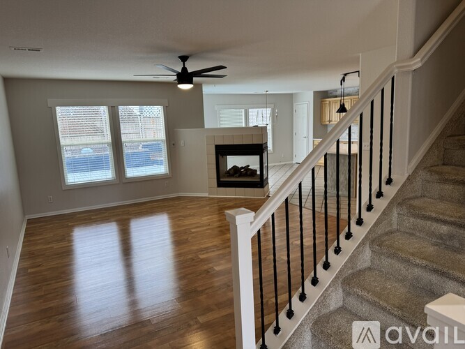 A living room with a fireplace and a staircase.