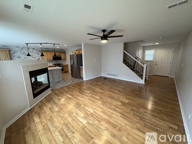 A spacious living room with a fireplace and hardwood flooring.