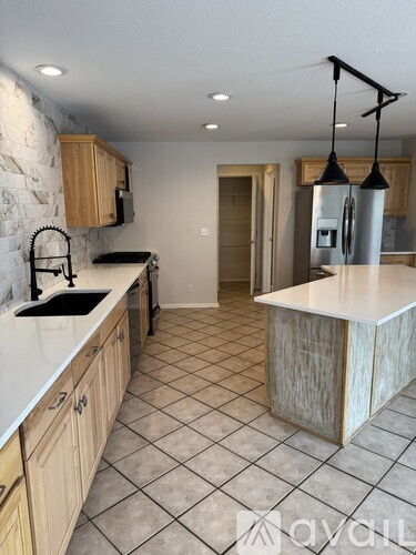 A kitchen with a white counter top and wooden cabinets.