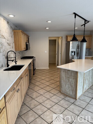 A kitchen with a white counter top and wooden cabinets.