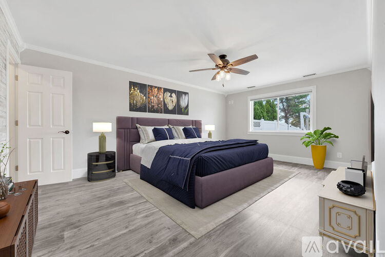 A bedroom with a large bed and a ceiling fan.