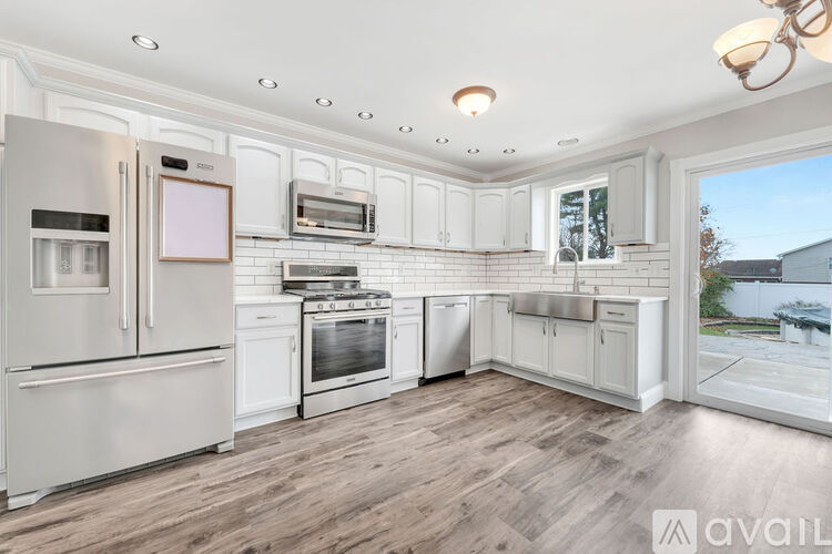 A modern kitchen with white cabinets and stainless steel appliances.