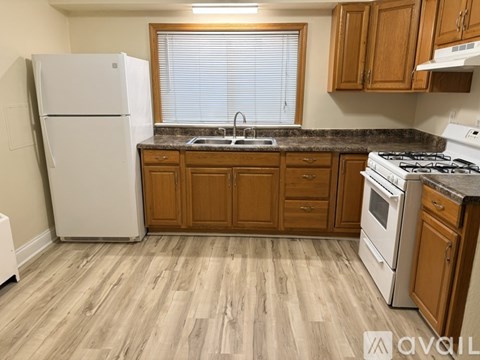 A kitchen with wooden cabinets and a white fridge.
