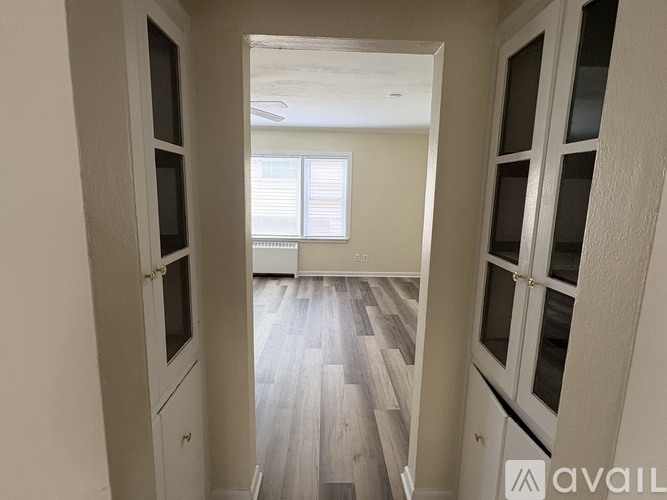 A hallway with wooden floors and white walls.