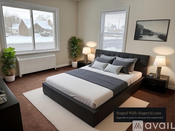 A bedroom with a large bed and a window showing a snowy landscape outside.
