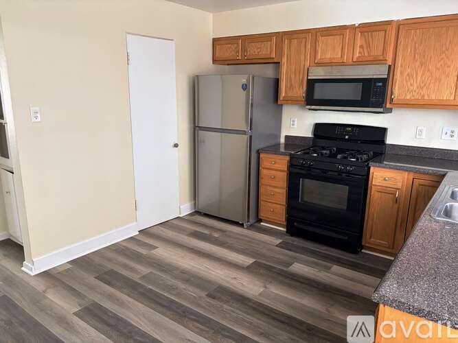 A kitchen with wooden cabinets and a black stove top oven.