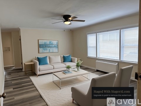 A living room with a white couch, a coffee table, and a painting on the wall.