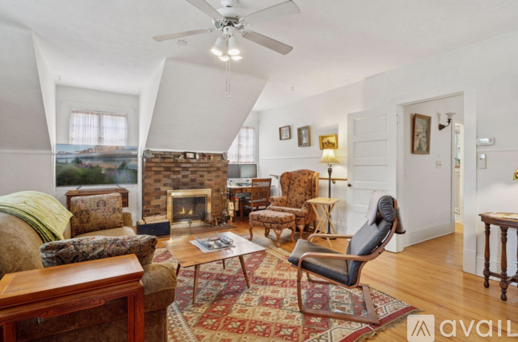 A living room with a fireplace and a chair.