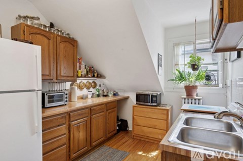 A kitchen with wooden cabinets and a white refrigerator.