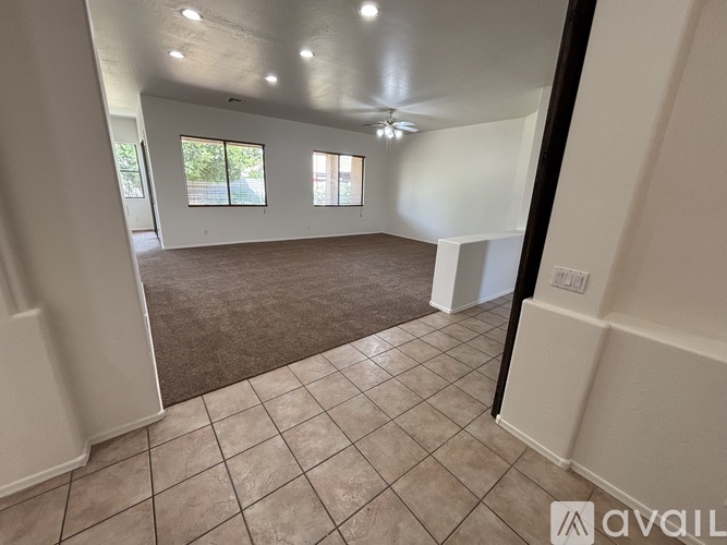 A spacious room with tiled flooring and a ceiling fan.