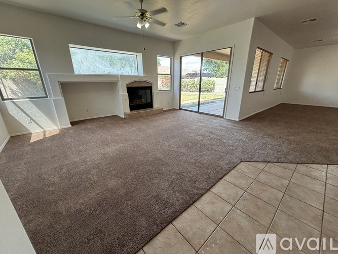 A spacious living room with a fireplace and sliding glass doors.