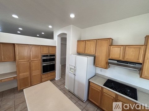 A kitchen with wooden cabinets and a white refrigerator.