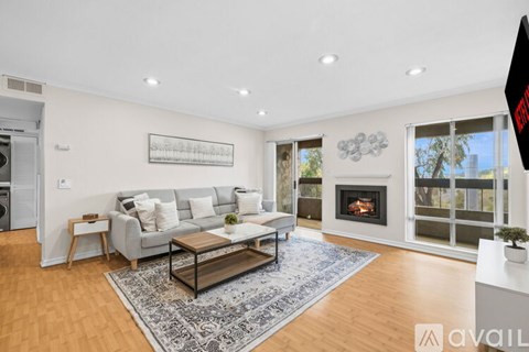 A living room with a grey couch and a fireplace.