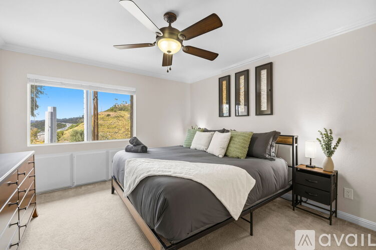 A bedroom with a large bed and a ceiling fan.