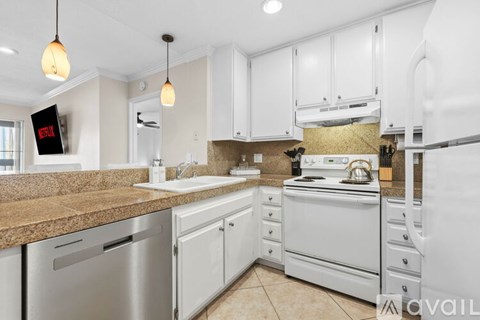 A kitchen with white cabinets and a stainless steel dishwasher.