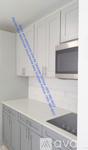 A white kitchen with a stove and a microwave.
