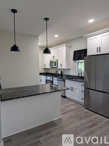 A modern kitchen with a black granite countertop and stainless steel appliances.