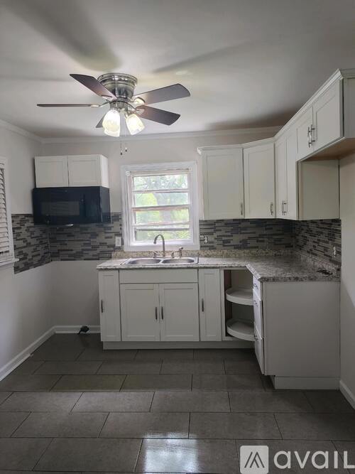 A kitchen with a fan and a window.