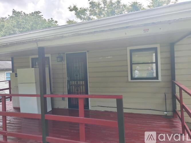 A small house with a red railing in front.