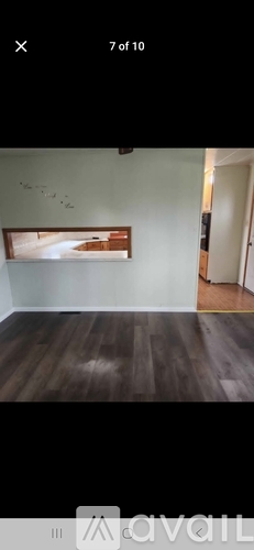 A room with wooden flooring and a painting on the wall.