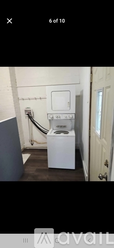 A white toilet with a tank lid is in a narrow room.