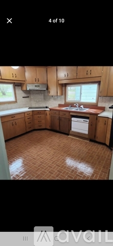 A kitchen with wooden cabinets and a tiled floor.