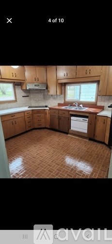 A kitchen with wooden cabinets and a tiled floor.