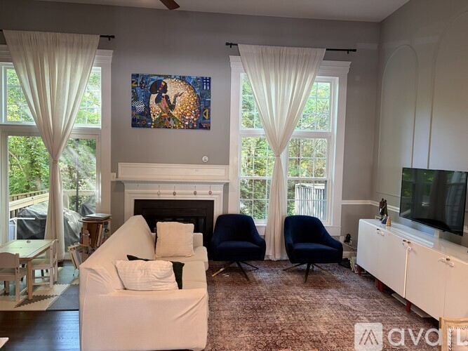 A living room with a fireplace and a painting on the wall.