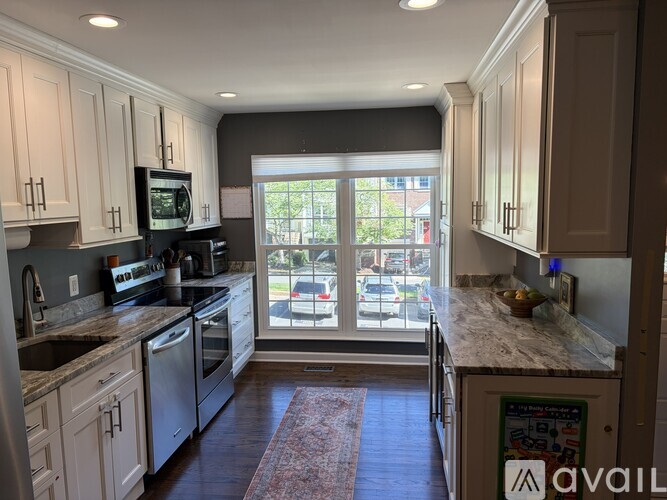 A kitchen with white cabinets and a granite countertop.