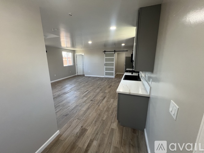 A kitchen area with wooden flooring and a white countertop.