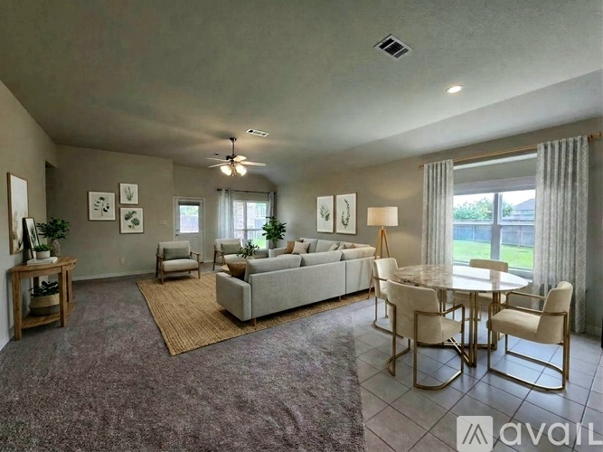 A living room with a grey couch, a dining table with chairs, and a rug on the floor.