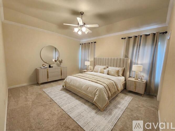 A bedroom with a large bed, a round mirror, and a ceiling fan.