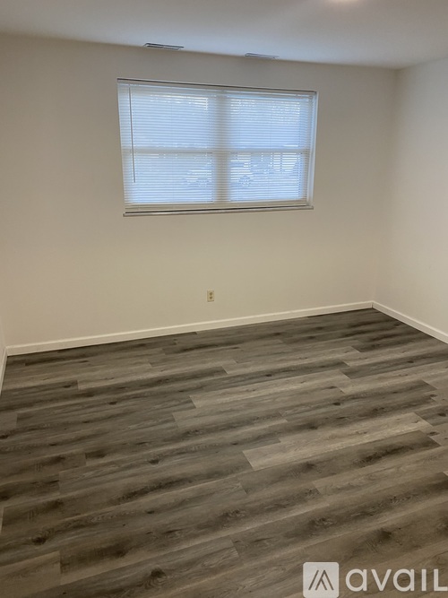 A room with a window and wooden flooring.