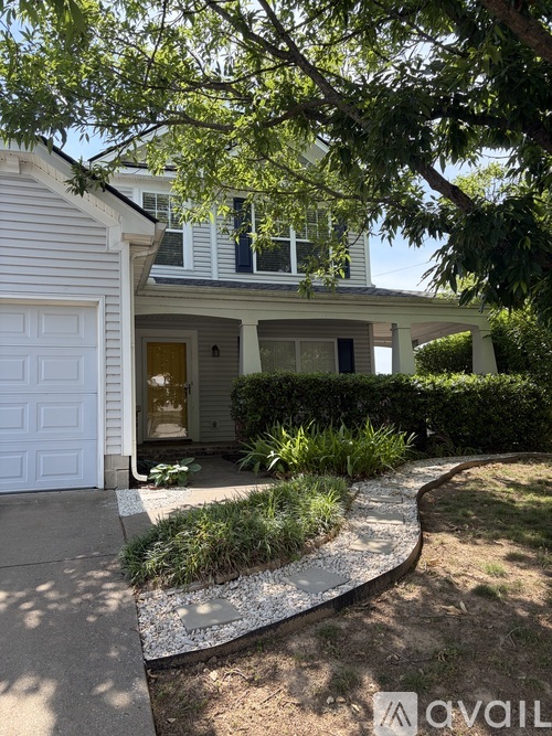 A white house with a garage door and a driveway.