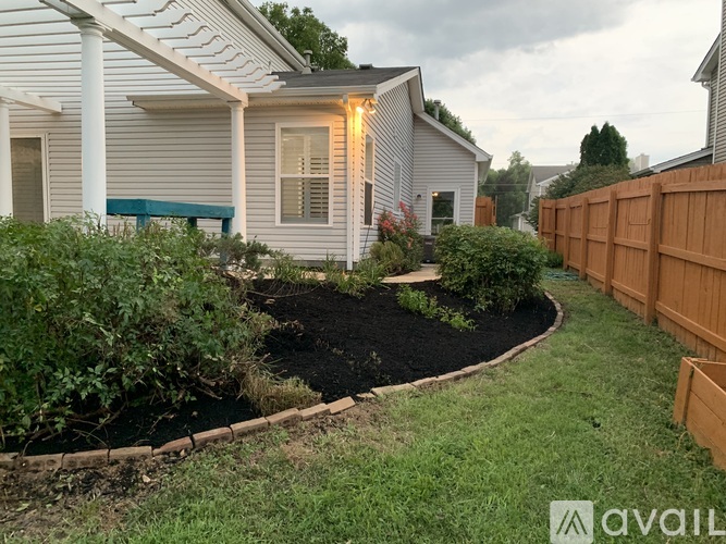 A backyard with a garden bed and a wooden fence.