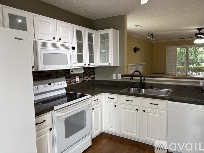 A kitchen with white appliances and cabinets.